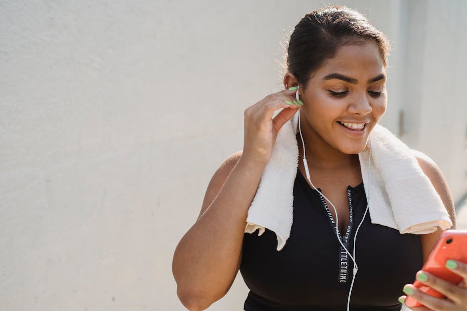 Woman in Sports Clothing Putting Earphones in and Smiling 